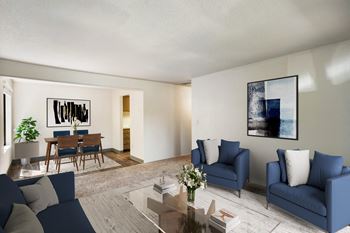A living room with blue couches and chairs and a dining room table